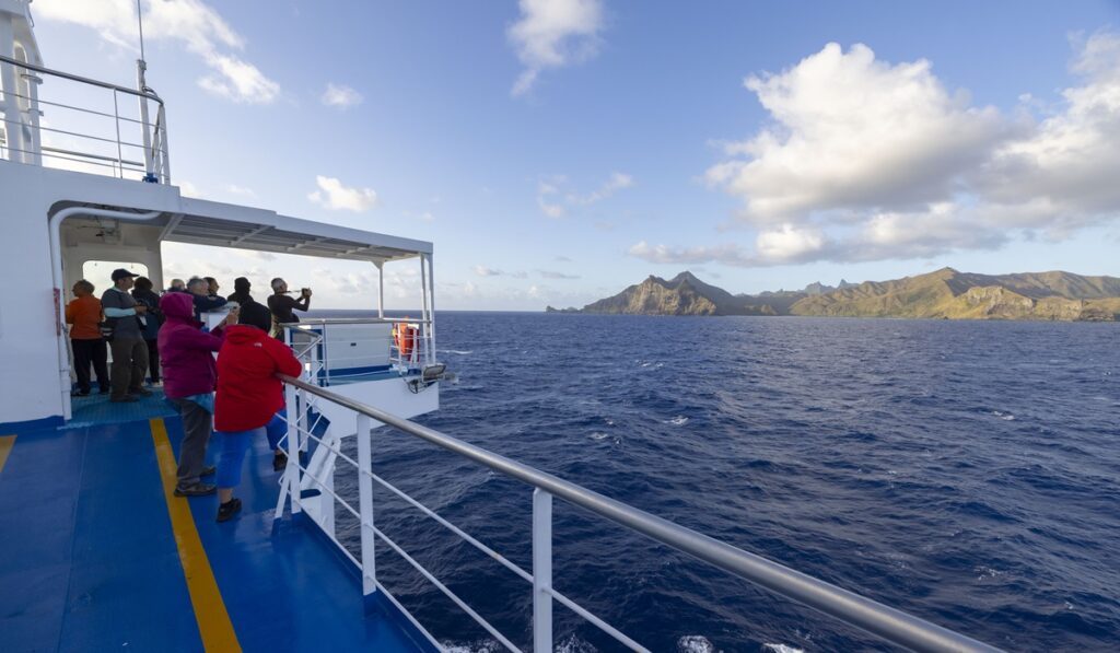 Croisière en Polynésie française : passagers sur le pont de l'Aranui 5 face aux îles volcaniques des Marquises