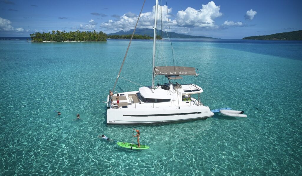 Catamaran au mouillage dans lagon avec baignade et paddle
