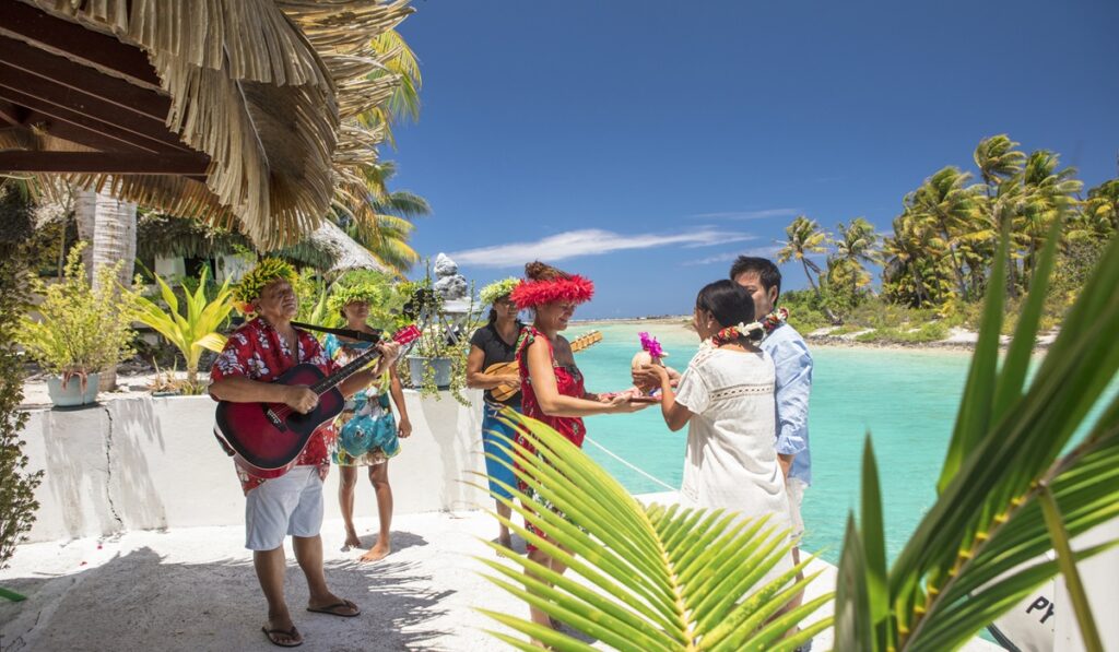 Accueil traditionnel polynésien en musique pour un couple au bord du lagon